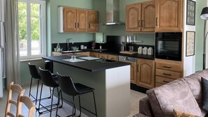 Une cuisine moderne avec des meubles en bois, un îlot central et des tabourets de bar.