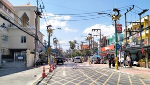 A street view with a crosswalk, buildings, and a restaurant named 'TUNA'. - Minotel Patong (Patong)