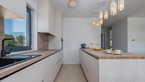 Una cocina moderna con encimera de madera, horno empotrado y ventana.