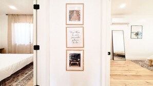 Ein Hotelzimmer mit einem Bett, einem großen Spiegel und drei gerahmten Bildern an der Wand.