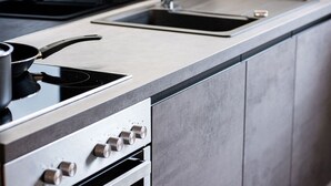 Une cuisine moderne équipée d’une cuisinière en acier inoxydable, d’un évier et d’une hotte aspirante.