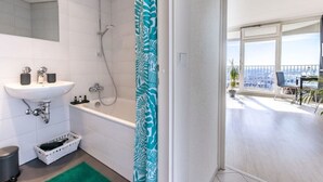 Un bagno moderno con vasca, lavabo e doccia.