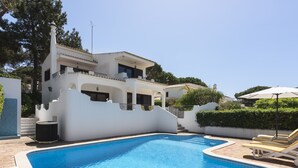 Uma casa moderna de dois andares, com piscina e área de estar ao ar livre.