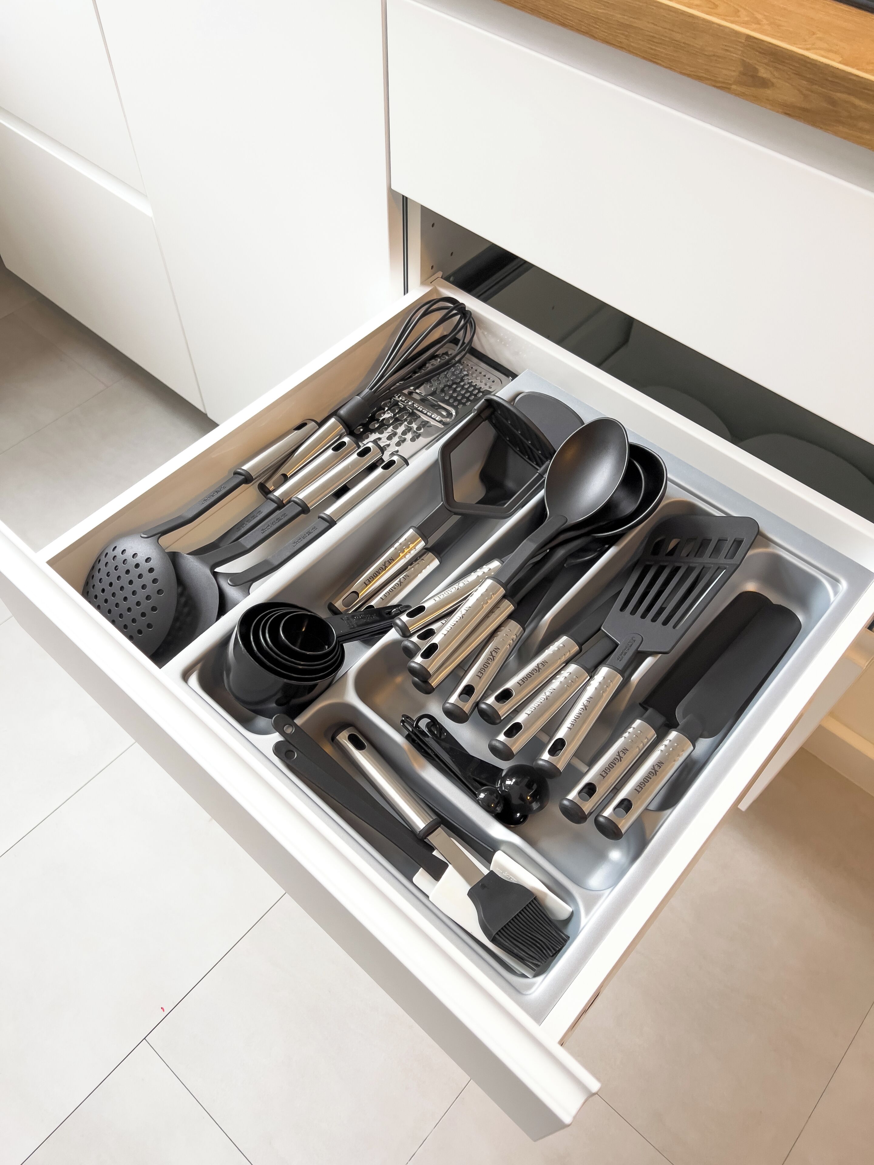 A kitchen drawer with various utensils neatly organized.