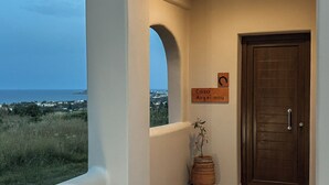 Un couloir donnant sur la mer, une porte en bois et une enseigne indiquant « Casa Avgerinou ».