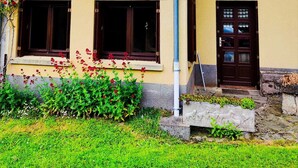 A two-story building with a balcony, a door, and a window. - Country house in Livradois Forez (Saint-Victor-Montvianeix)