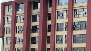 Un immeuble à plusieurs étages, doté d’une façade beige et de bandes verticales rouges.