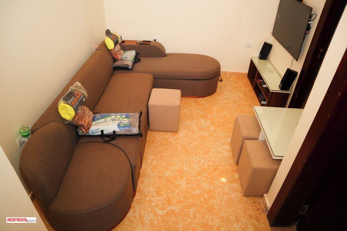 A living room with a sectional sofa, a small table, and a TV.
