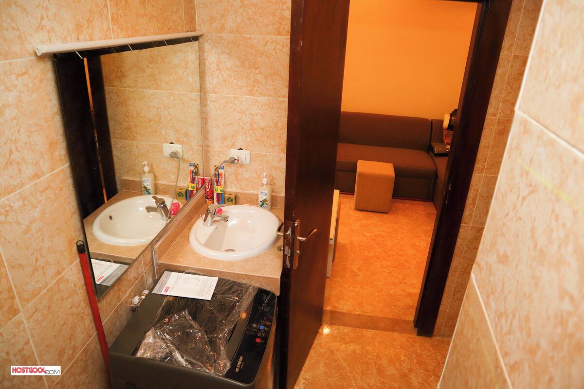 A bathroom with two sinks, a mirror, and a toilet.