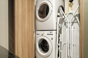 A stacked washer and dryer unit with a metal drying rack attached. - Luxury 1BR in Reforma · Pool, Spa & Skyline (Mexico City)