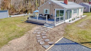 A single-story house with a covered porch and a stone pathway leading to the entrance. - Beachy 3 bedroom home with central air, just .5 miles to the beach (Dennis Port)