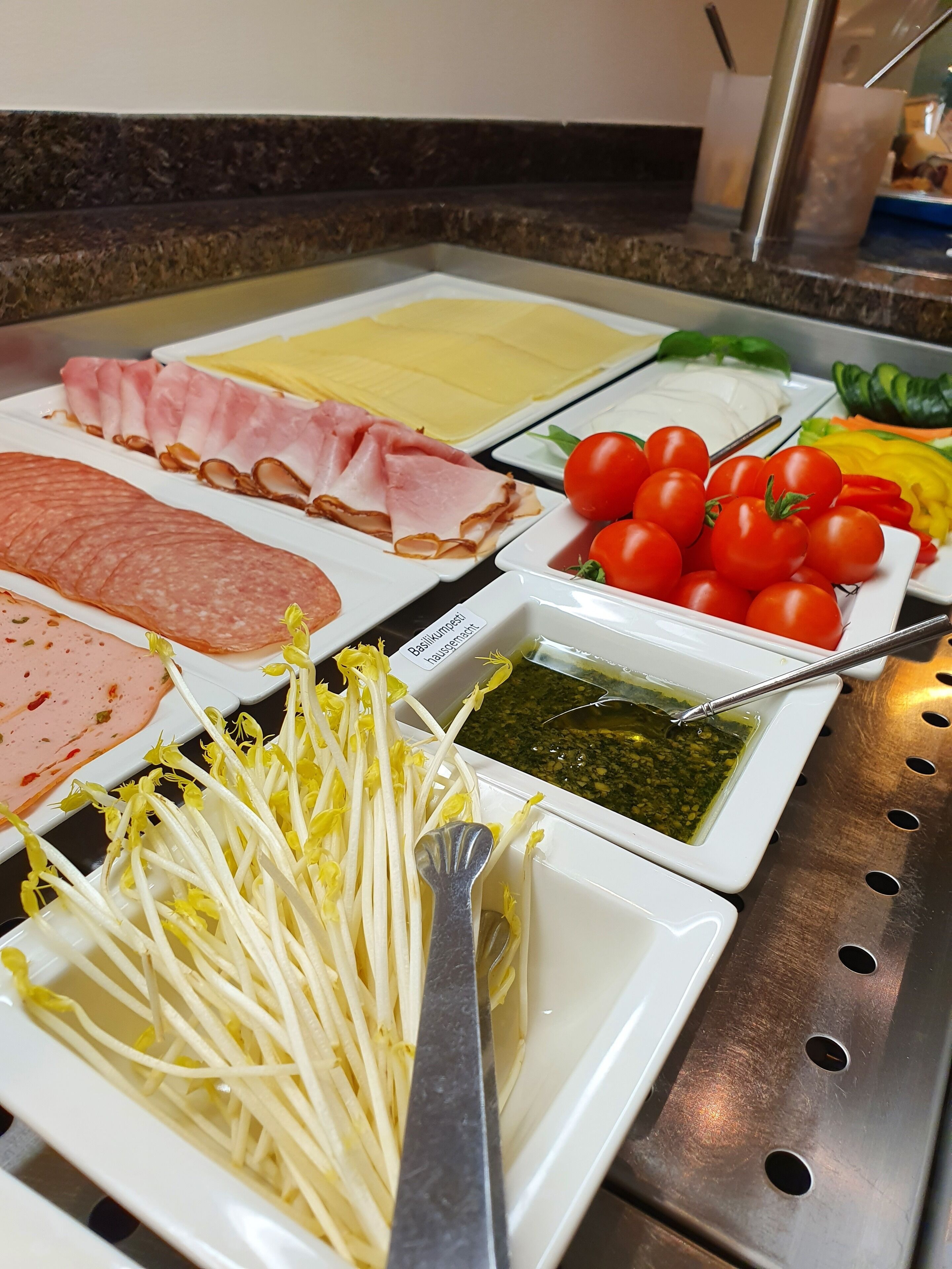 A buffet with various food options including meats, cheeses, and vegetables.