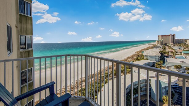 A balcony with a view of a beach and ocean.