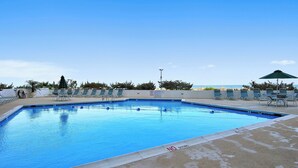 Une piscine dont la profondeur est indiquée à 3 pieds, des chaises longues et une vue sur l’océan.