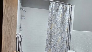 Ein Badezimmer mit Dusche, Toilette und Waschtisch.