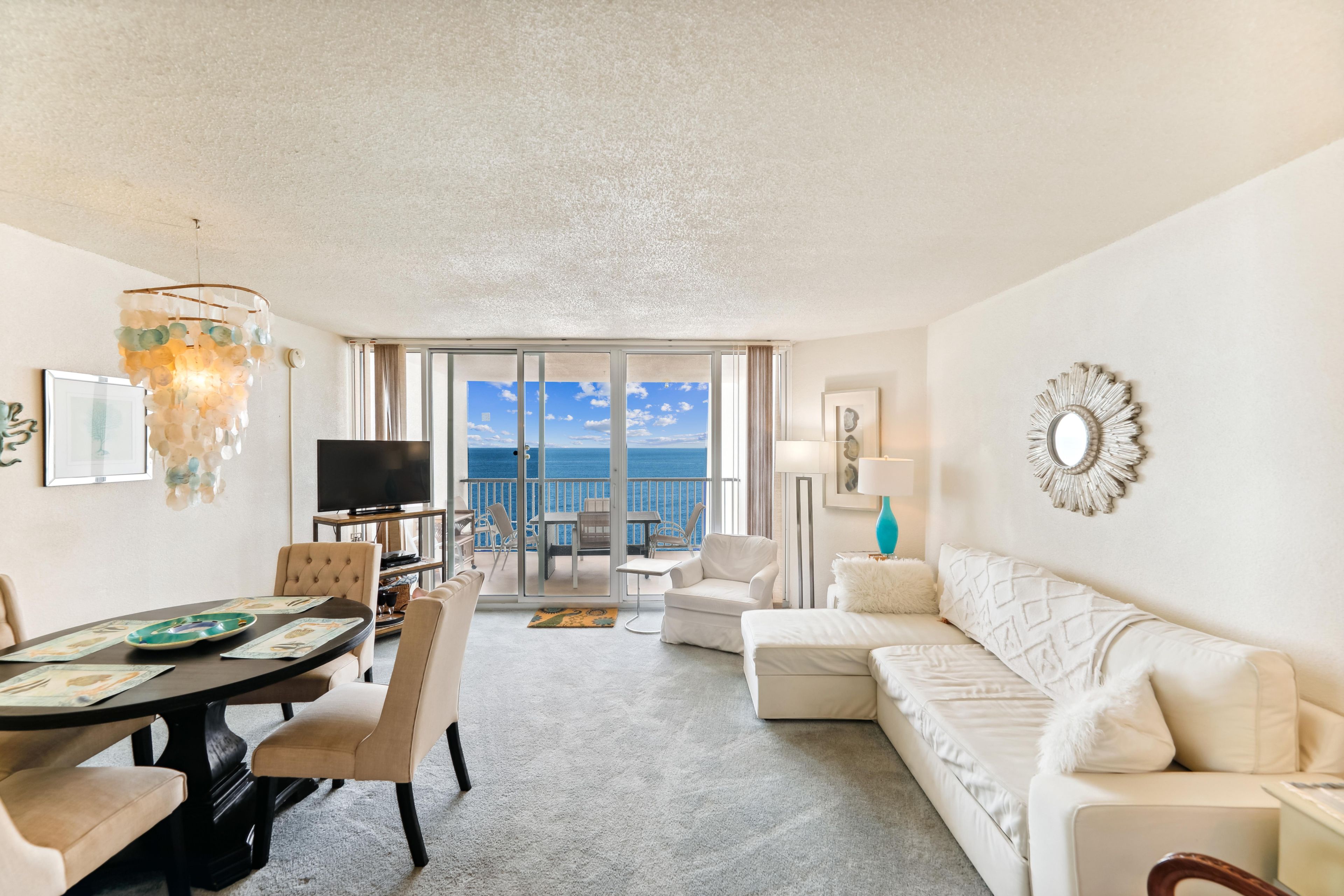 Une chambre d’hôtel avec un balcon, un coin repas et un salon.