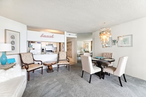 A dining area with a chandelier, chairs, and a table.