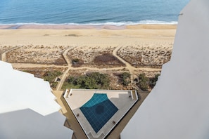 Una piscina en la azotea con vista a la playa y al océano.