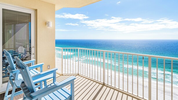 A balcony with a view of the ocean, a white railing, and blue chairs. - Unwind to Visions of the Sea (Panama City Beach)