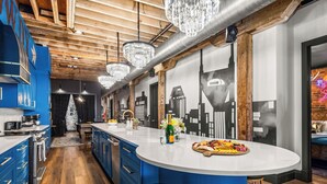 Una cocina moderna con gabinetes azules, una isla grande y una araña.