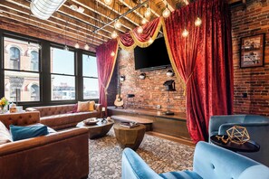 Ein gemütlicher Lounge-Bereich mit Ledersofas, einer Bartheke und einem großen Fernseher.