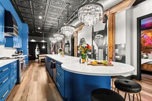 A modern kitchen with blue cabinets, a central island, and a decorative ceiling. - The Velvet Vault-Luxury Downtown loft with River View & walk to Broadway (Nashville)