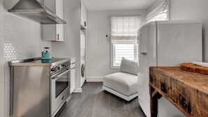 A compact kitchen with a built-in oven, a stove, and a washing machine. - LARGE HOME, CLOSE TO THE BEACH! (REHOBOTH BEACH)
