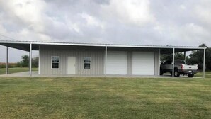 A single-story metal building with a covered porch and two garage doors.