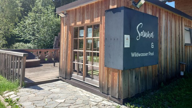 A wooden building with a sign reading "Sundh & Wildwaser Pool". - AlpiNest Apartment Samspitze 2 (Mariapfarr)