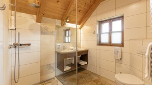 A bathroom with a shower, sink, and toilet.