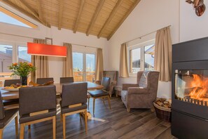 A cozy room with a dining area, a fireplace, and a view of the outdoors.