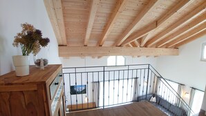 A wooden staircase with a metal railing leading to a balcony. - Kitzview Terrace Apartment (Zell am See)