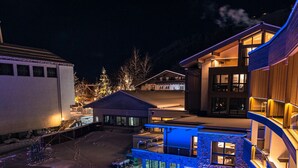 A modern hotel with a pool area, multiple buildings, and a snowy landscape.