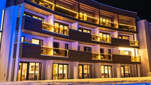 A multi-story hotel with balconies and a pool area.