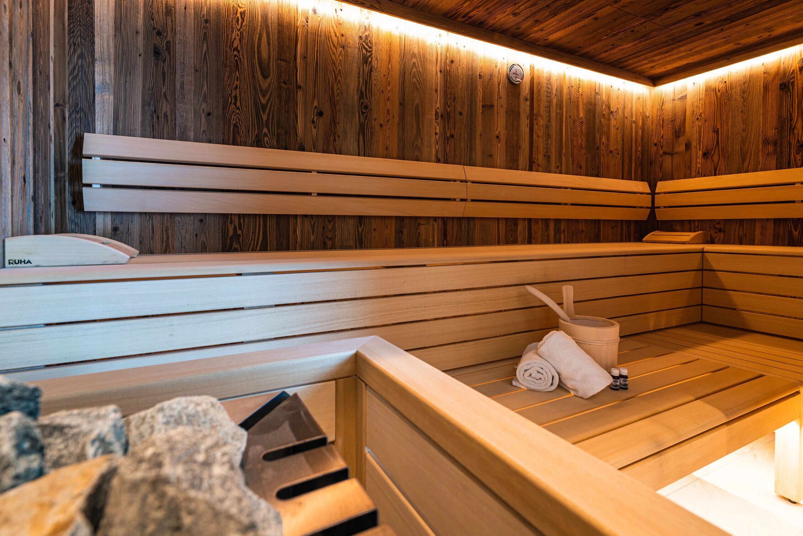 A wooden sauna with benches and a bench with a towel and a brush.
