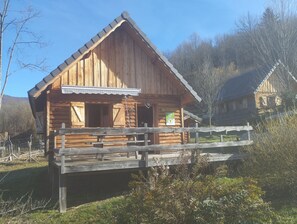 Eine Holzhütte mit geneigtem Dach, einer Holzveranda und einem Schild.