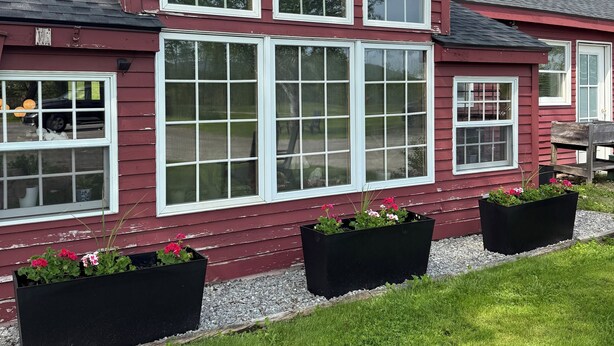 A two-story house with a red exterior and white trim. There are three large windows on the front and a chimney on the right side. - COHO Inn & Motor Lodge (Weston)