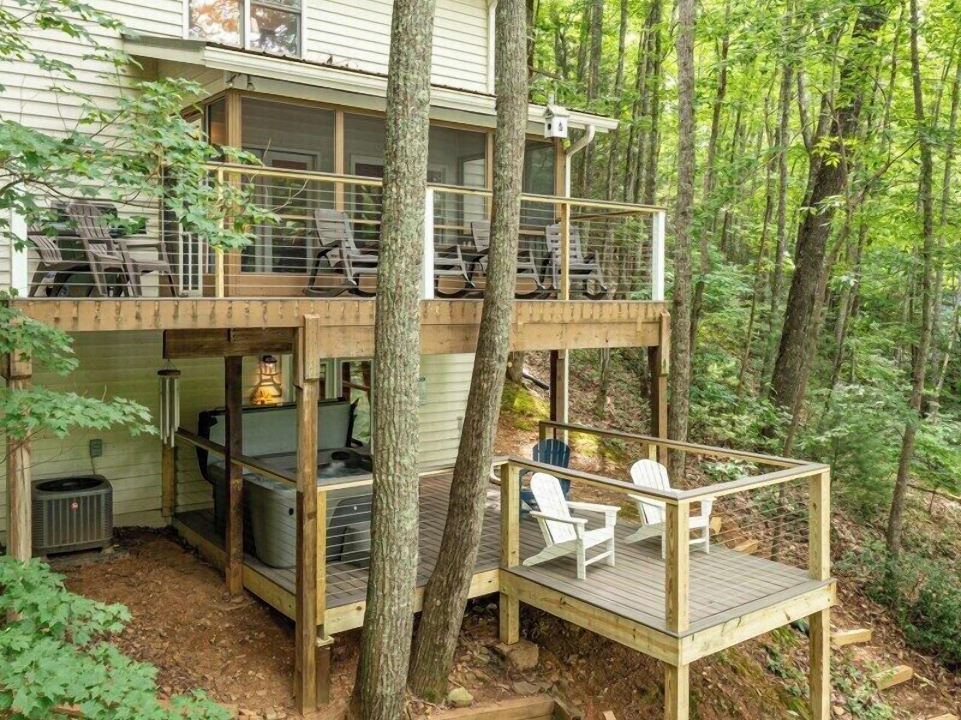 Eine zweistöckige Holzterrasse mit Sitzgelegenheiten und einem Kamin.