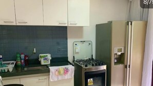 A compact kitchen with a gas stove, oven, and a refrigerator. - Stunning 2-bed Apartment in Pipa Beach (Tibau do Sul)