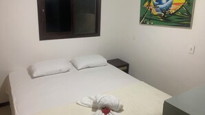 A bedroom with a bed, pillows, a window, a nightstand, and a painting on the wall. - Stunning 2-bed Apartment in Pipa Beach (Tibau do Sul)