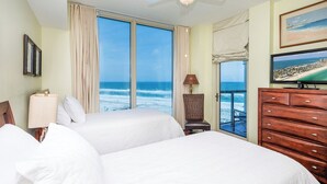 A hotel room with two beds, a ceiling fan, a TV, and a view of the ocean. - Beautiful Gulf Front Condo P1-0908 (Pensacola Beach)