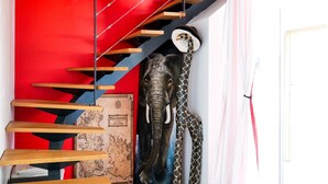 Una escalera con escalones de madera y una pared roja.