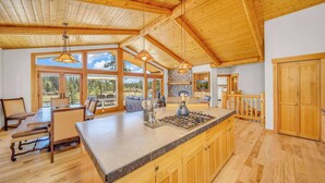 Une cuisine spacieuse avec des meubles en bois, un grand îlot central et des luminaires suspendus.