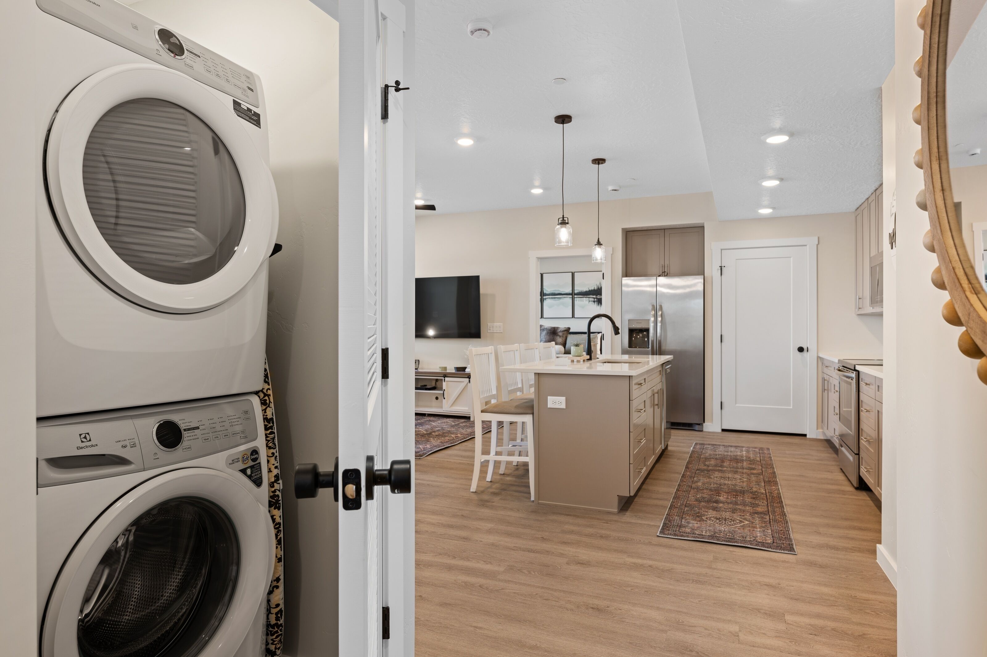 A modern kitchen with a central island, built-in appliances, and pendant lighting.