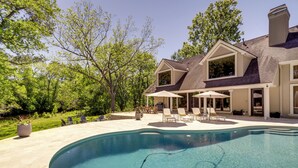 A modern house with a swimming pool, outdoor seating, and a landscaped garden. - Private 25 Acre Estate w/ Lake: Fish & Canoe! (Houston)