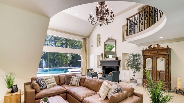 A spacious living room with a large sectional sofa, a fireplace, and a view of a swimming pool. - Private 25 Acre Estate w/ Lake: Fish & Canoe! (Houston)