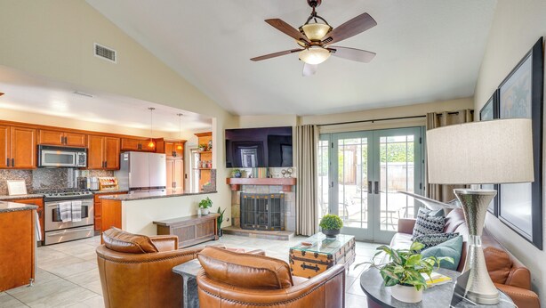 A spacious living area with leather chairs, a fireplace, and a dining area with wooden cabinets and a microwave.