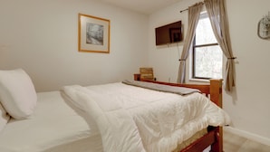 A neatly made bed with a wooden headboard, a framed picture on the wall, and a window with curtains. - Fishing Pond & Smoky Mtn Views: Couple's Getaway (Sevierville)