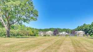 A large grassy field with a row of two-story buildings in the background. - Livin Wells' Retreat, 2 Mi to Drakes Island Beach (Wells)