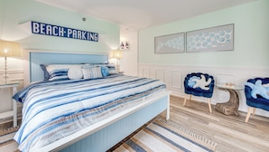 A bedroom with a bed, a chair, a small table, and a sign that reads "BEACH PARKING". - Livin Wells' Retreat, 2 Mi to Drakes Island Beach (Wells)